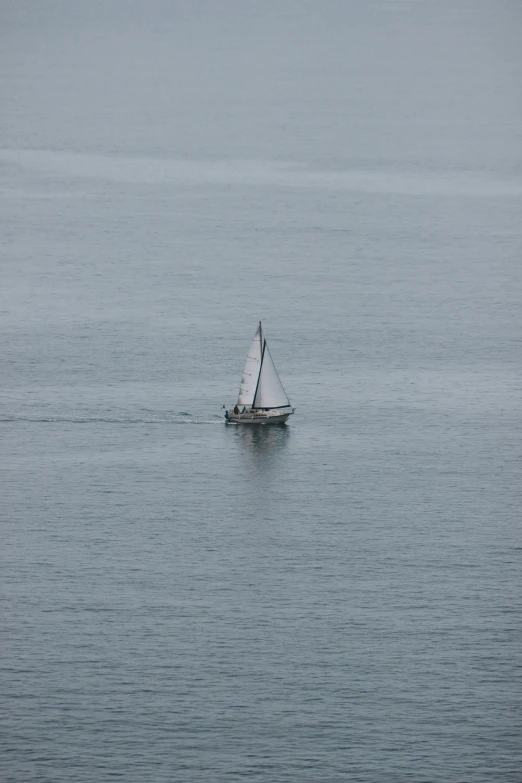 a single sailboat in the water with no sails