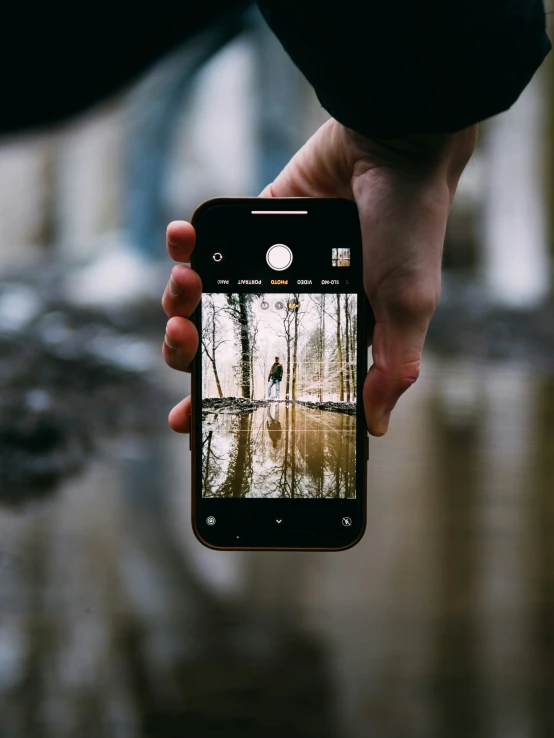 a person holding a cell phone with a reflection in the lens