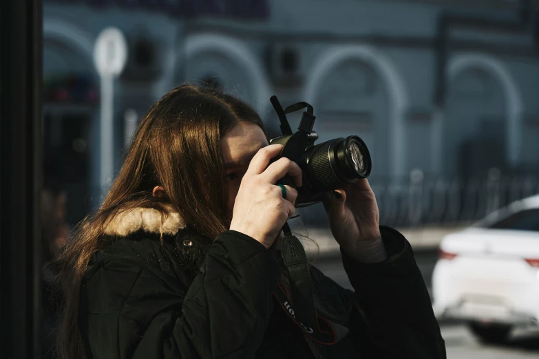 a woman standing next to a street holding a camera