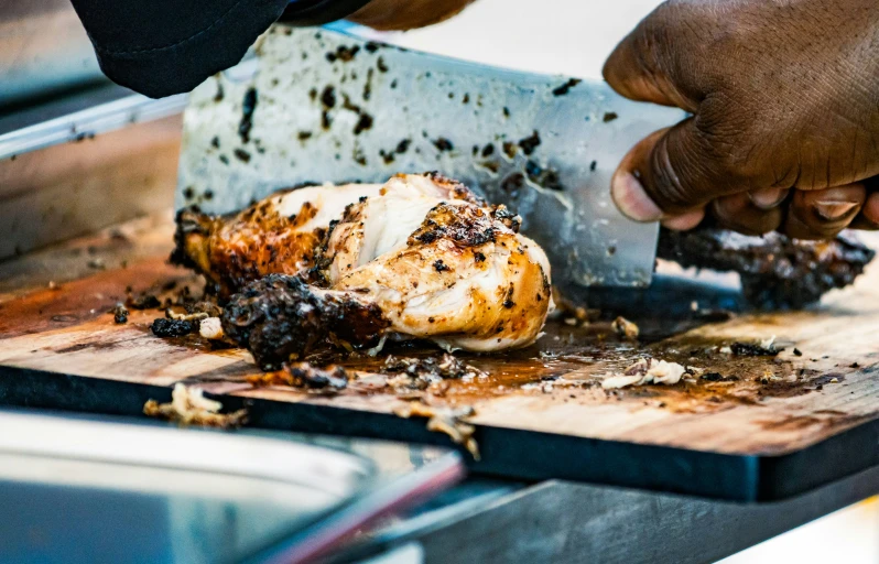 man cuts up a large piece of meat on a  board