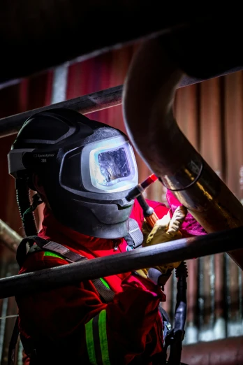 a man in safety gear checking out a hose with a light on
