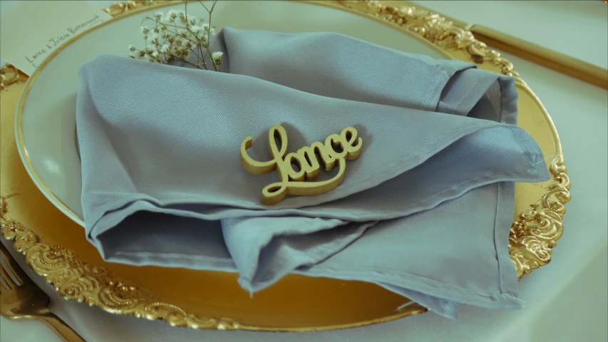 a blue napkin sits on a gold - plate