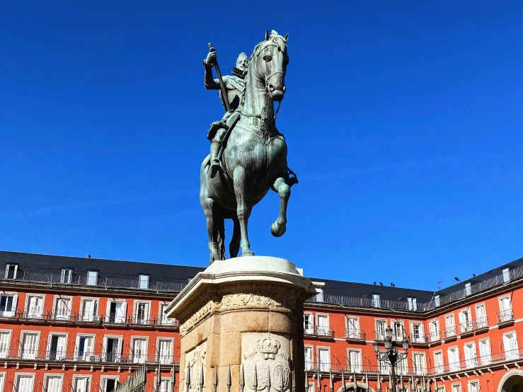 a statue in front of a building with a clock on it