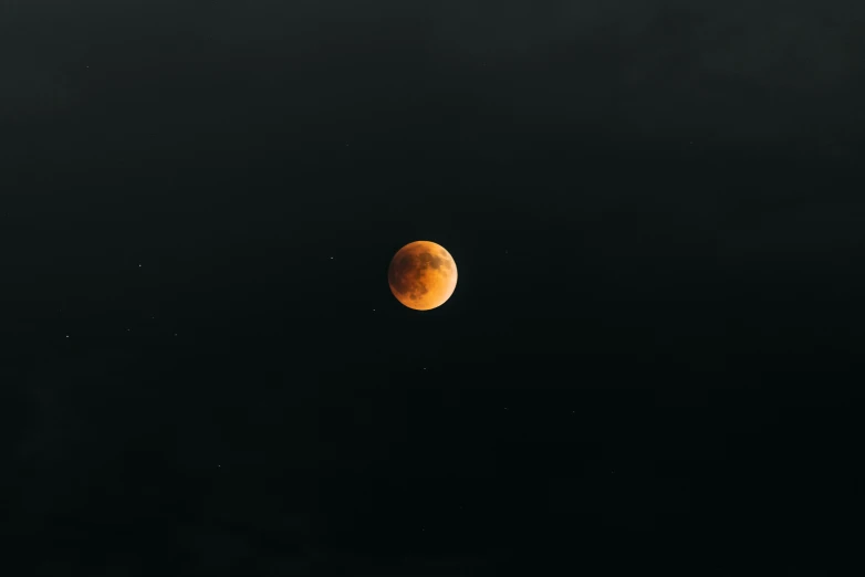 a moon is shown from below the dark clouds