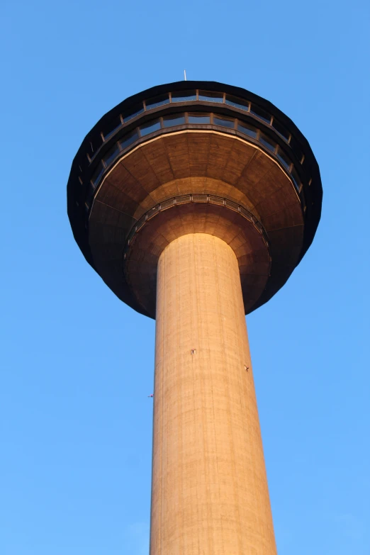 the tall column of a building with a plane flying in front