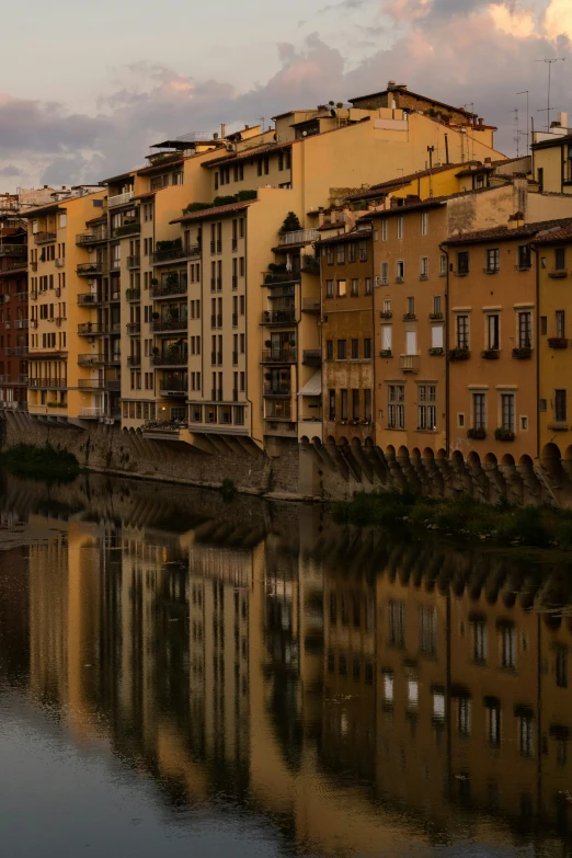 many buildings are next to a river with a bridge