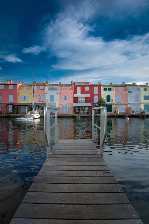 a wooden dock with a boat near a house