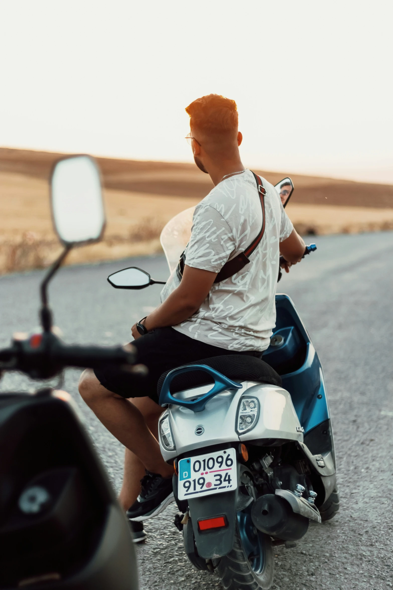 a man is on a motorcycle driving down the road