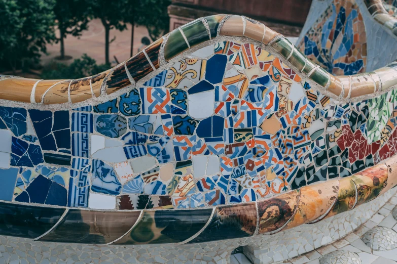 colorful tiles on the bottom of a bench on a city sidewalk