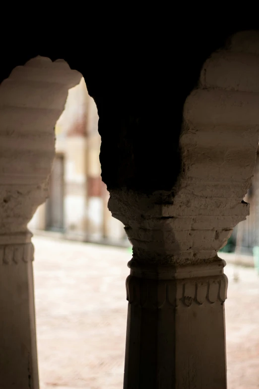 a black cat is sitting on a pillar outside