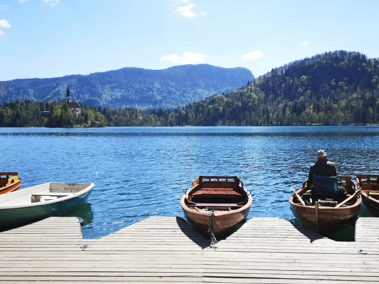 a dock with three rowboats on the water