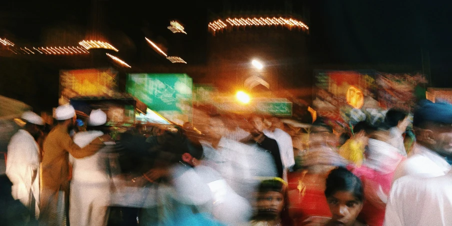 blurry image of people in front of store signs at night