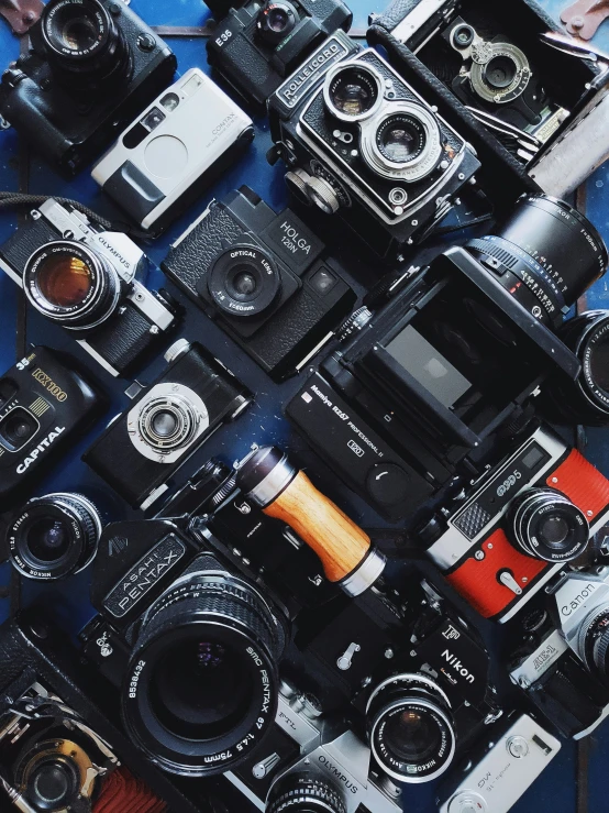 a big blue blanket filled with different types of cameras