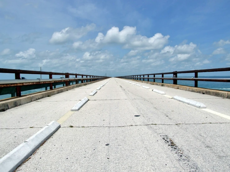 the ocean is close to the pier lines and it's white gravel