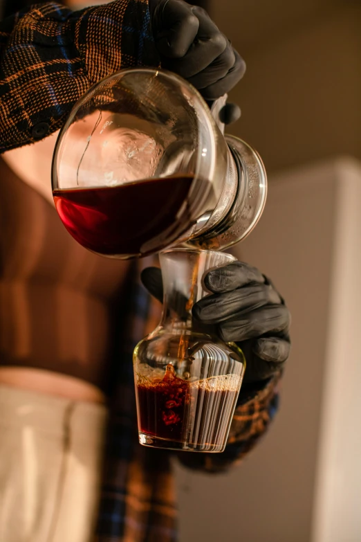 someone pouring some kind of drink into a glass