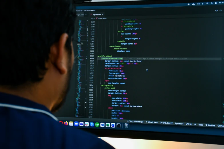 a man looking at an array of code on his computer