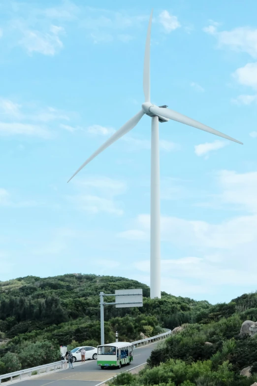 a bus passes a wind turbine on the freeway