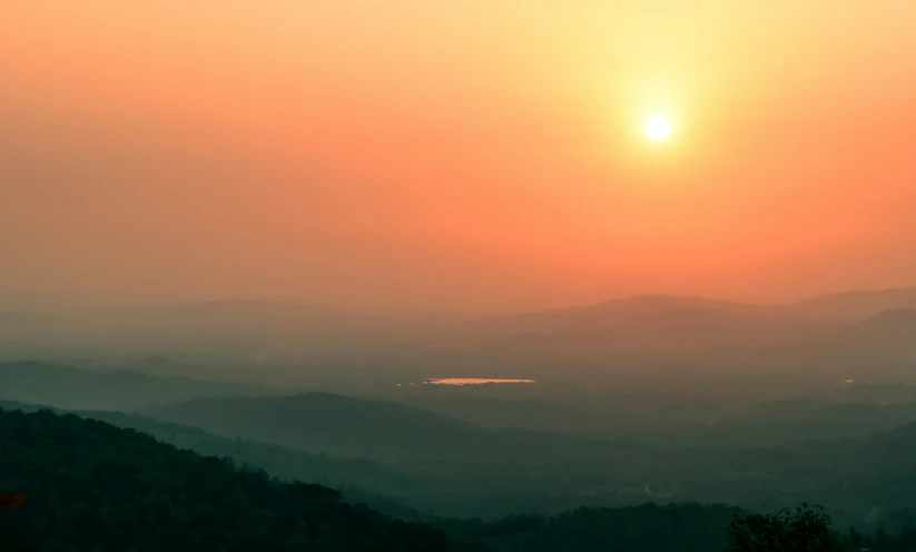 the sun is setting on top of mountains