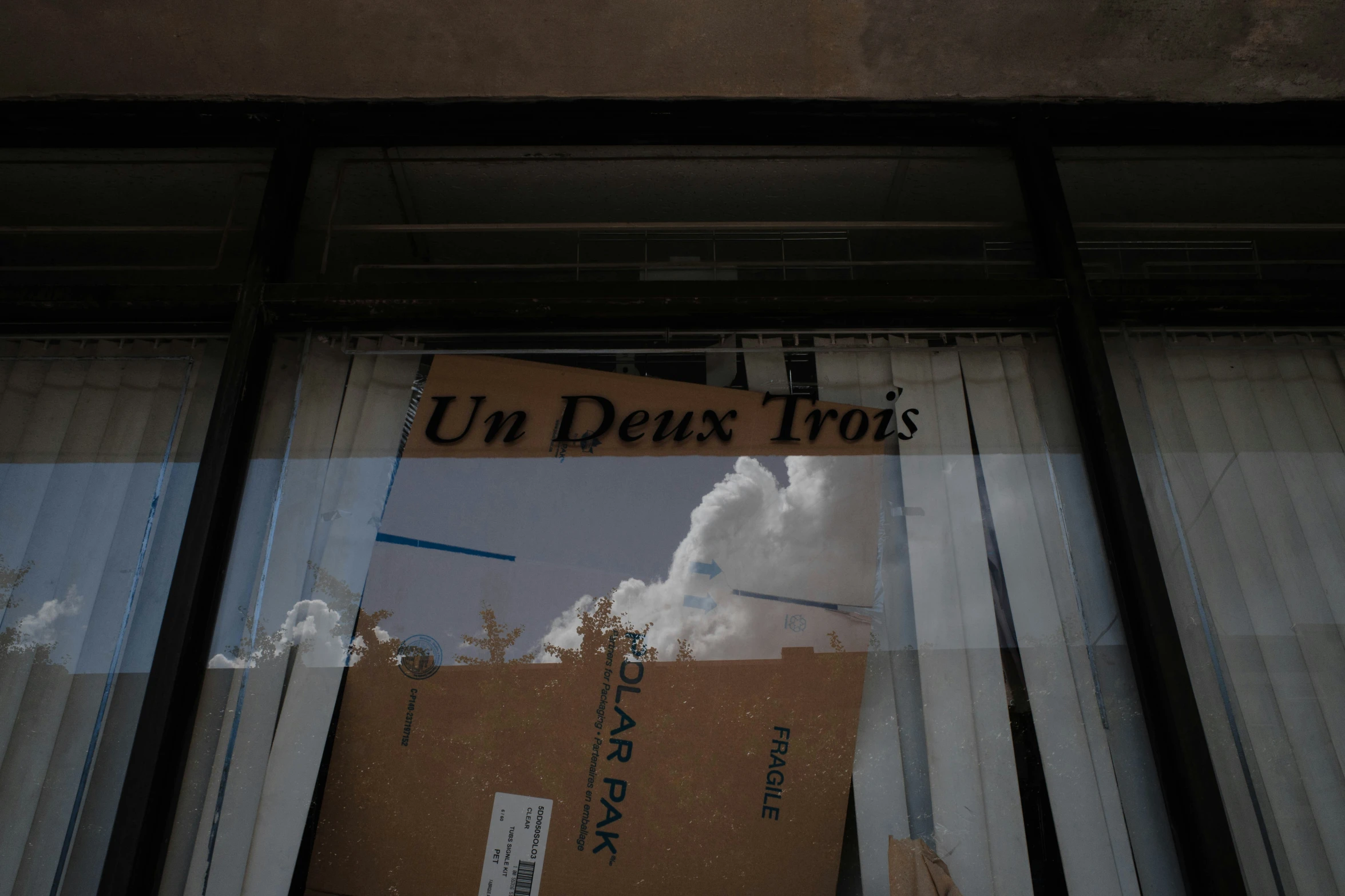 a closed door is reflected in the window of an industrial building