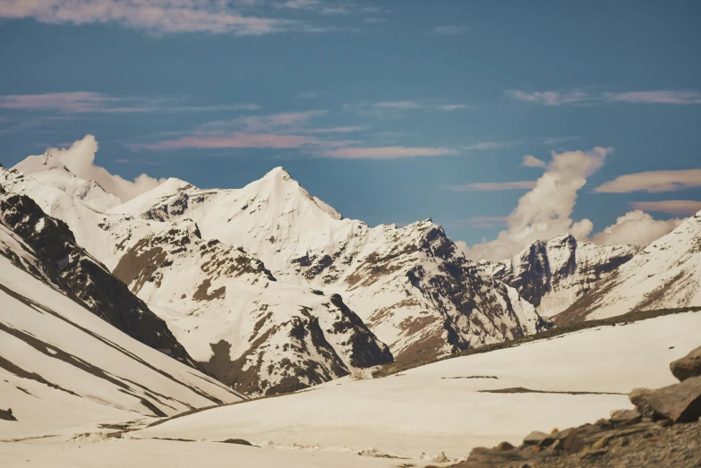 there are clouds in the sky above the mountain tops