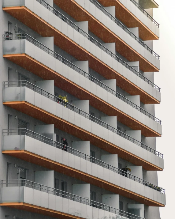 two people on a balcony on top of a tall building