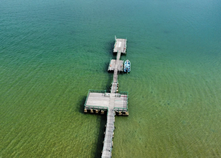 two boats parked at the end of a wooden pier