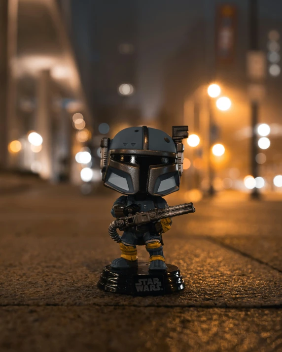 a lego bobble head standing on a sidewalk