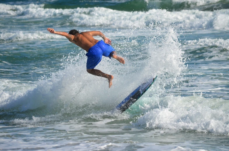 a man is surfing on a blue surfboard