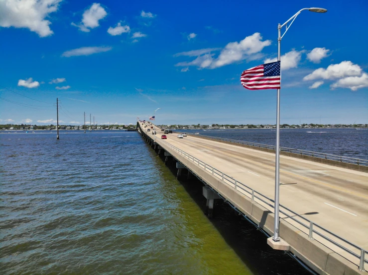 an american flag is flying on the pier next to a lake