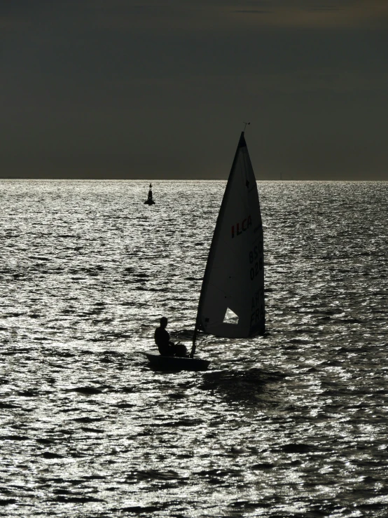 a person is sailing on a sail boat in the ocean