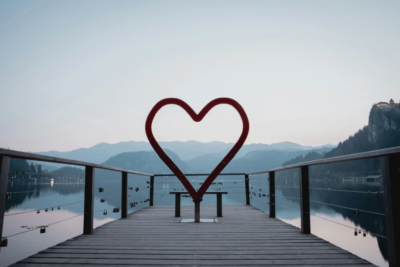 a heart shaped object is standing on the pier