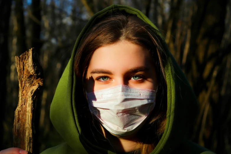 a woman wearing a mask and holding a stick