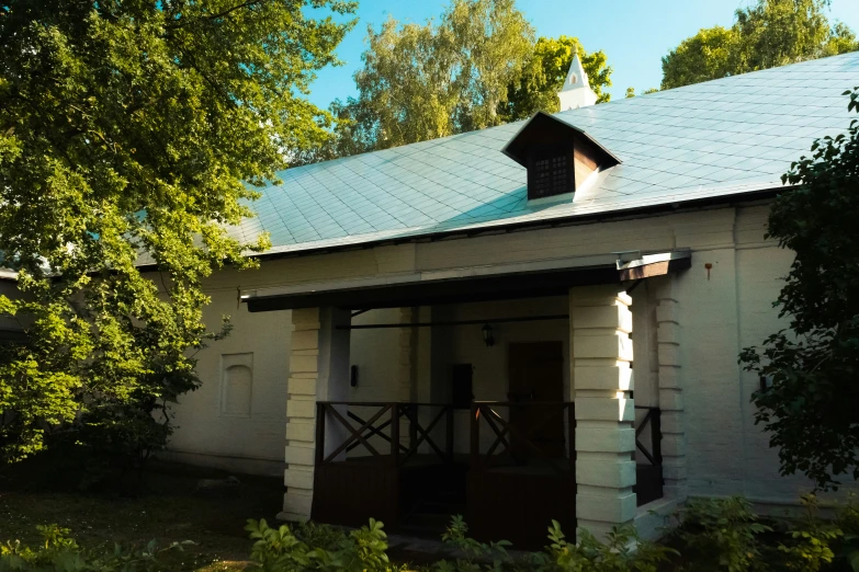 an old fashioned wooden house has metal roof and columns