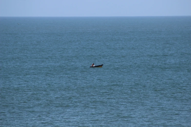 the lone fishing boat sails out into the ocean