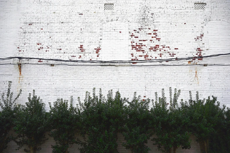 an old sign on a brick wall has red paint on it