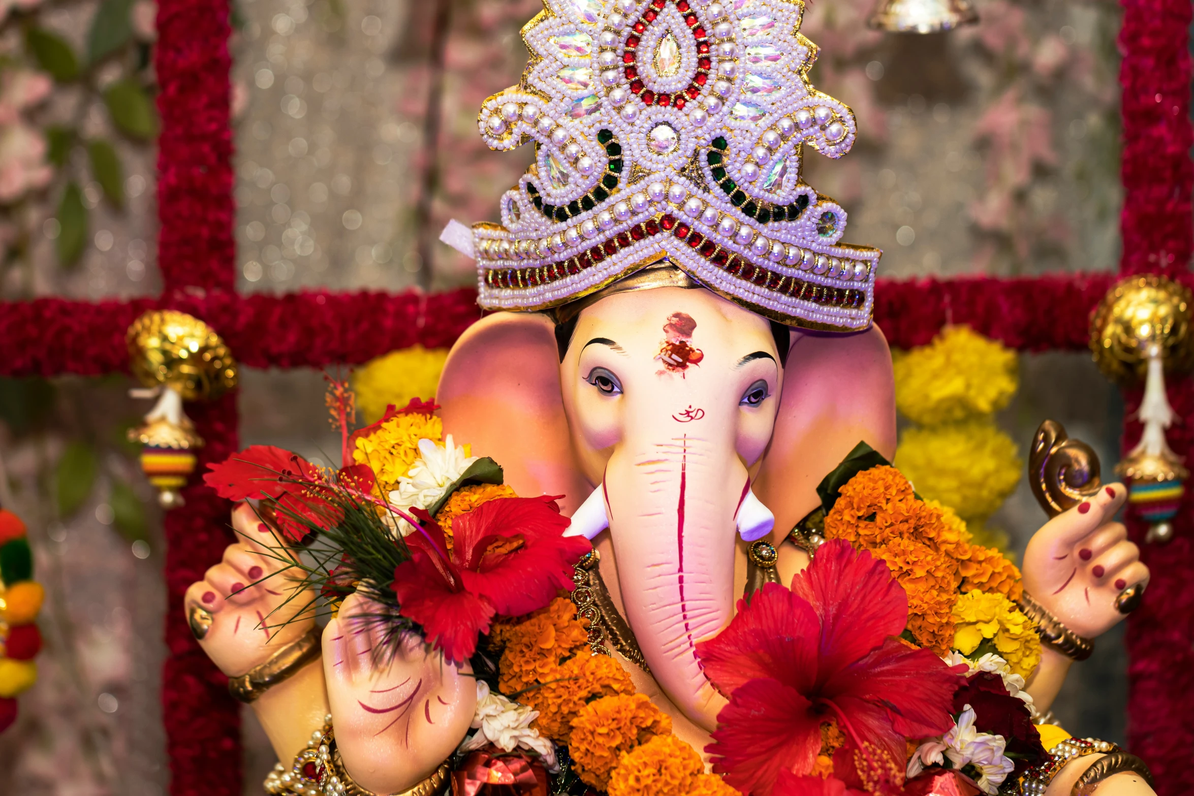 an elephant that is decorated with decorations in front of a wall