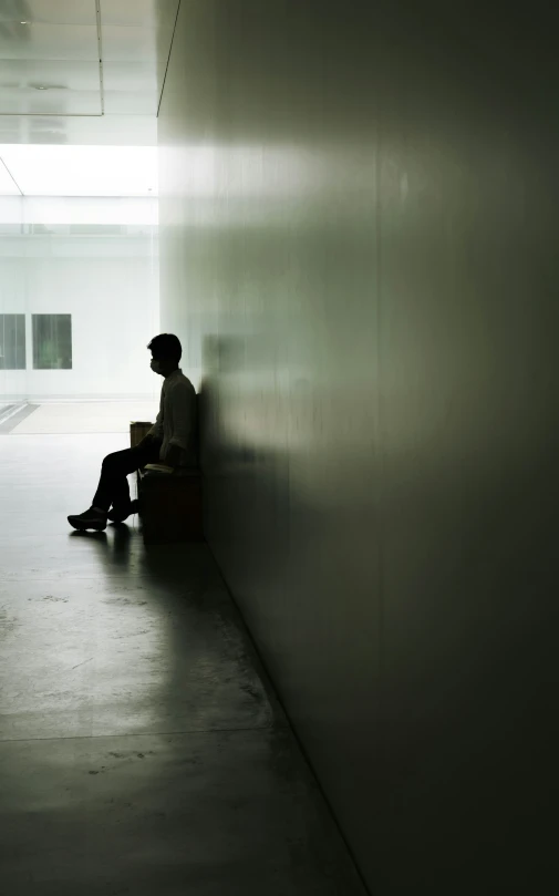 a person sitting down and looking at the ground