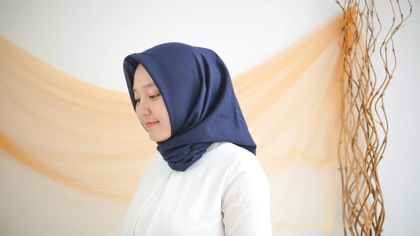 a woman wearing a blue hijab and a white shirt