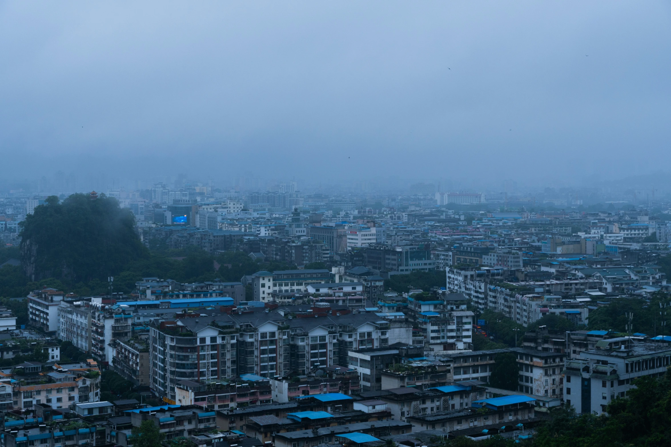 the skyline of the city, with blue roofs, stands over the hill