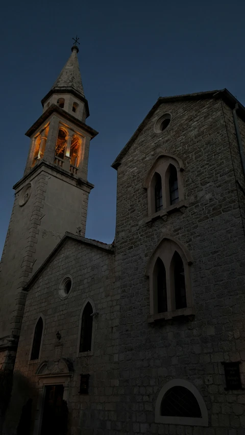 the tower is made of stone and features a bell