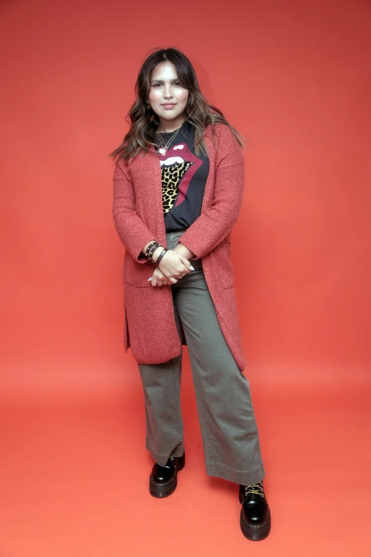 a woman posing in front of a red backdrop