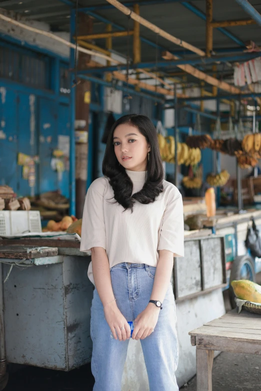 a woman standing in a market area holding her purse