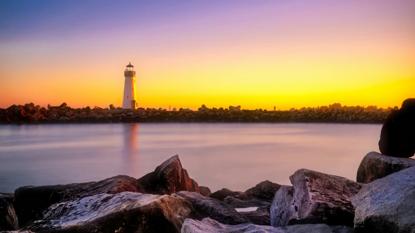 a beautiful sunset in a small town with a light tower