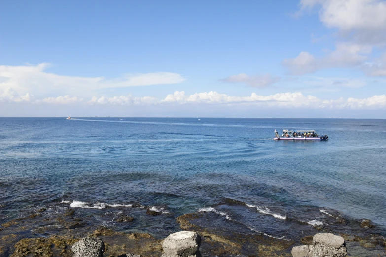 the sea is clear and blue with a boat on it