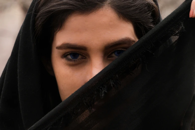 a close up of a person's face and black scarf