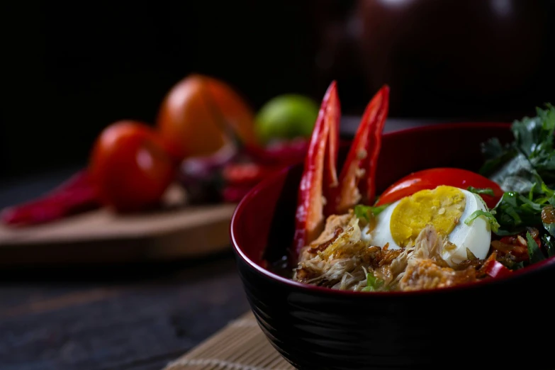 the food in the black bowl is served in a red bowl