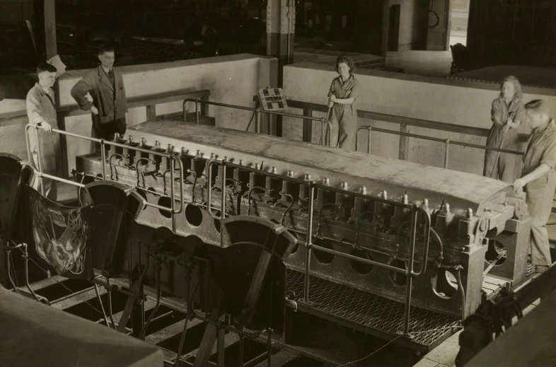 four men look over the side of an engine block