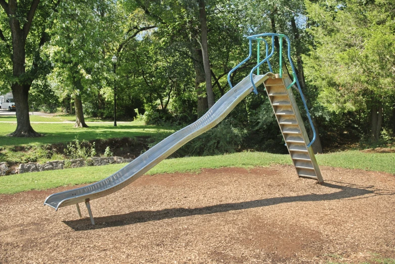 a slide in the middle of a field in a park