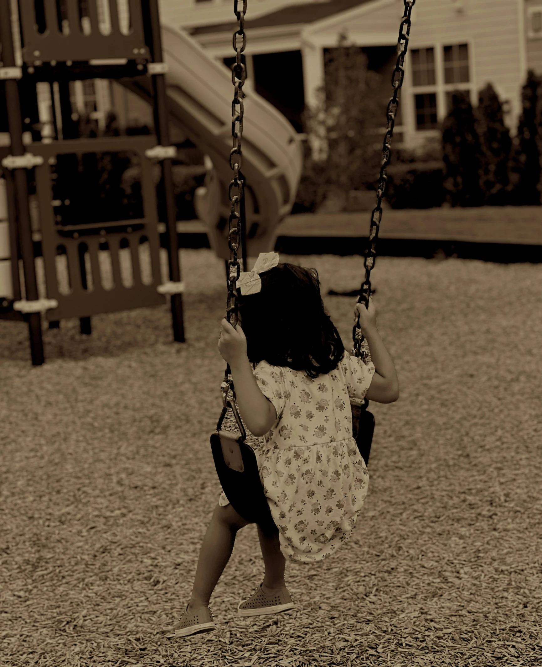 a  is sitting in a swing at the park