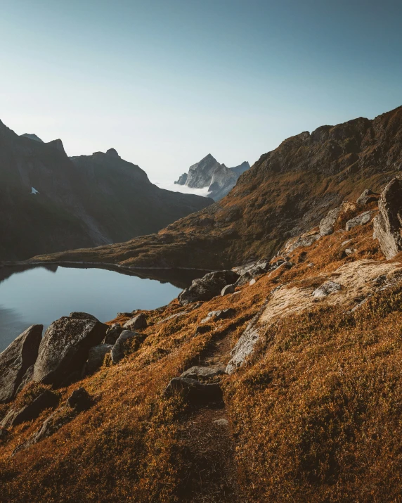 a body of water sitting on top of a lush green hillside